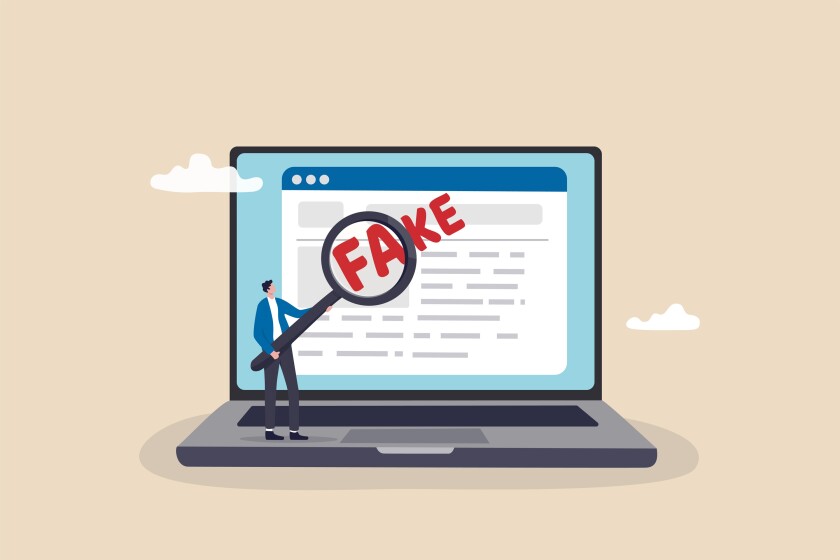 Fake news or false information spreading on website and social media, screening or verify truth before sharing or believe concept, man with magnifying glass verify fake news on website on computer.