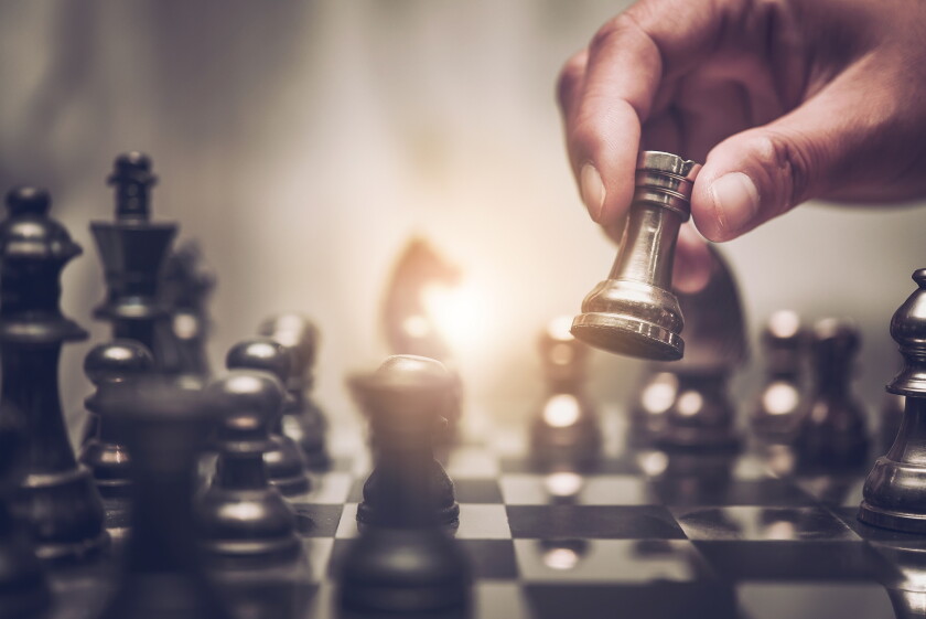 Businessman moving chess piece on chess board game concept for i