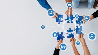 Collaborative Teamwork Concept with Puzzle Pieces, Hands Reaching for Solutions, and Interactive Connectivity in a Modern Workspace Environment. Amity