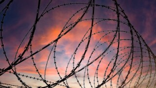 Silhouette of a barbed wire fence steel jail