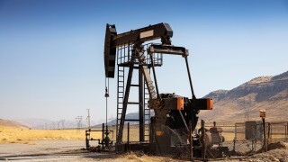 Oil drilling derricks at desert oilfield. Crude oil production from the ground. Oilfield services contractor. Oil drill rig and pump jack. Petroleum production, natural gas, liquids, NGL, additive.