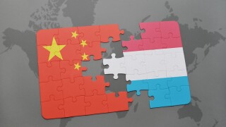 puzzle with the national flag of china and luxembourg on a world map background.