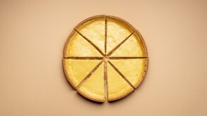 Sliced cheesecake on a yellow background. Equal sliced cake