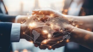 Map with connecting networks against a background of shaking hands
