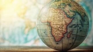 Adventure stories background. Old globe on map background. Selective focus.